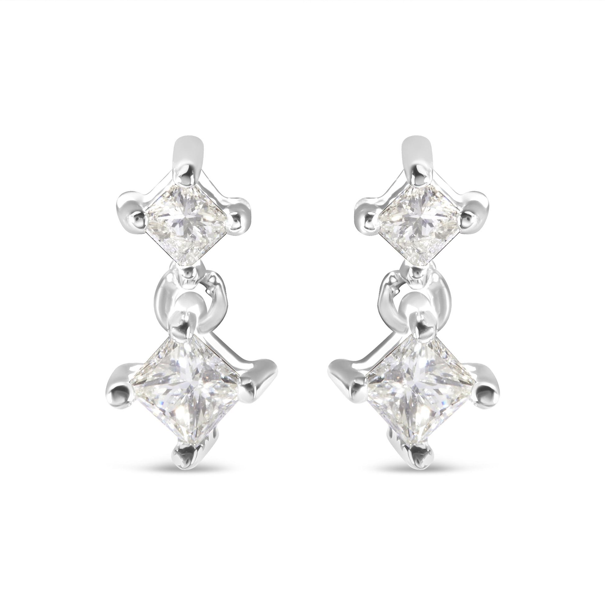 Front view of a pair of white metal earrings with two princess-shaped white gemstones in prong settings connected by a small link.