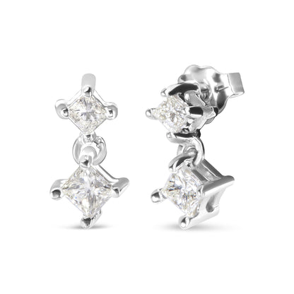 Close-up image of white metal earrings with two hanging princess-shaped white gemstones in prong settings, shown from front and side angles.