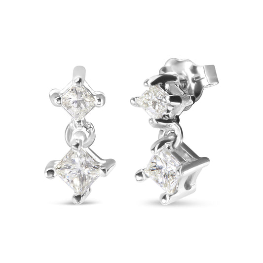 Close-up image of white metal earrings with two hanging princess-shaped white gemstones in prong settings, shown from front and side angles.