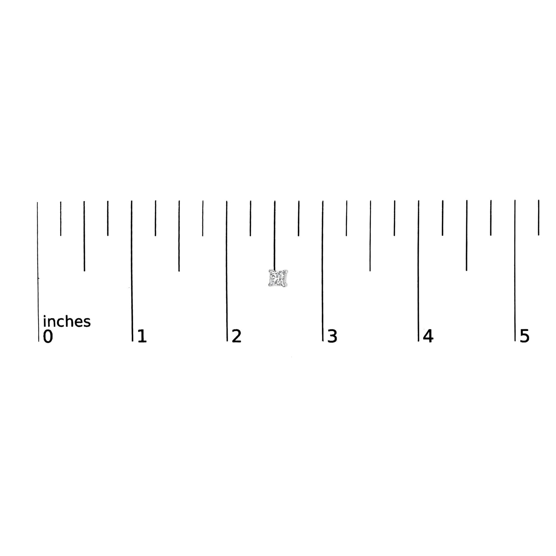 Close-up of a single white metal earring with a princess-shaped white gemstone in a prong setting, shown on a ruler for size reference.