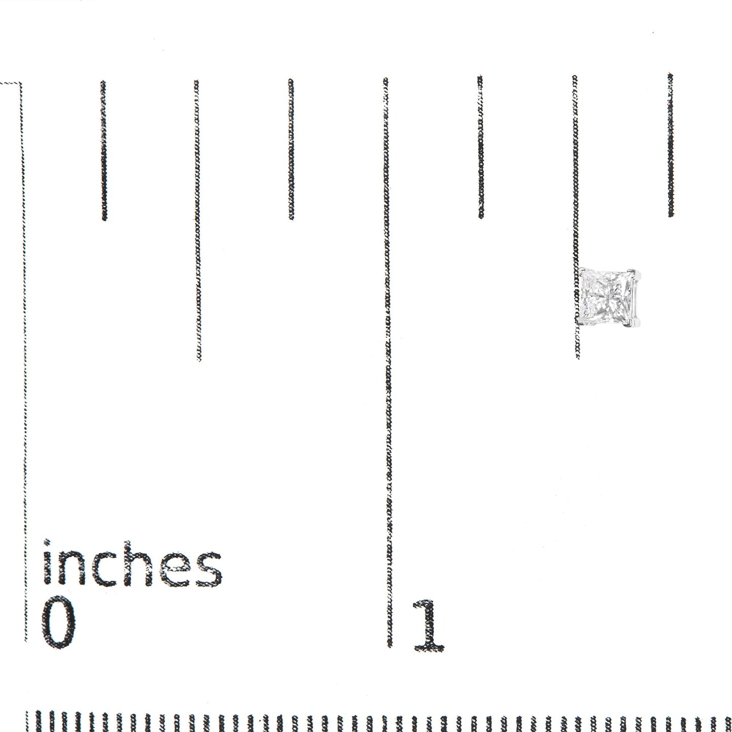 Close-up front view of a white metal earring with a princess-shaped white gemstone in a four-prong setting, placed on a ruler for size reference.