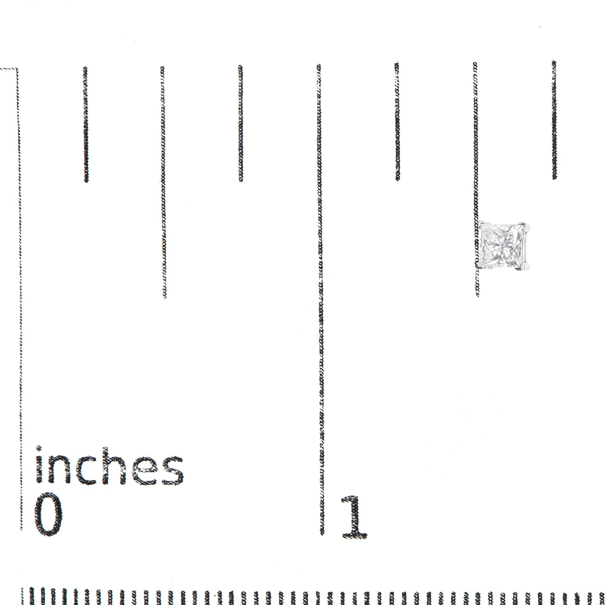 Close-up front view of a white metal earring with a princess-shaped white gemstone in a four-prong setting, placed on a ruler for size reference.