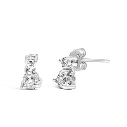 Front and side view of white metal stud earrings with two round white gemstones in three-prong settings.