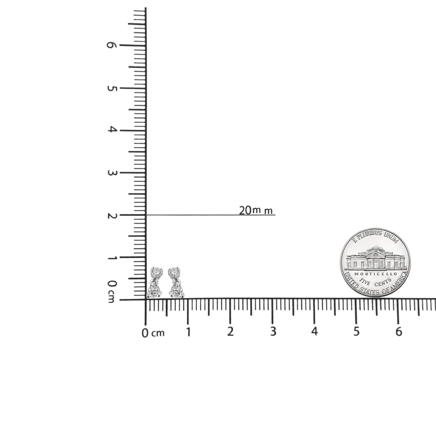 Close-up angled front view of white metal drop earrings with two round white gemstones in prong settings, shown on a ruler for size reference.