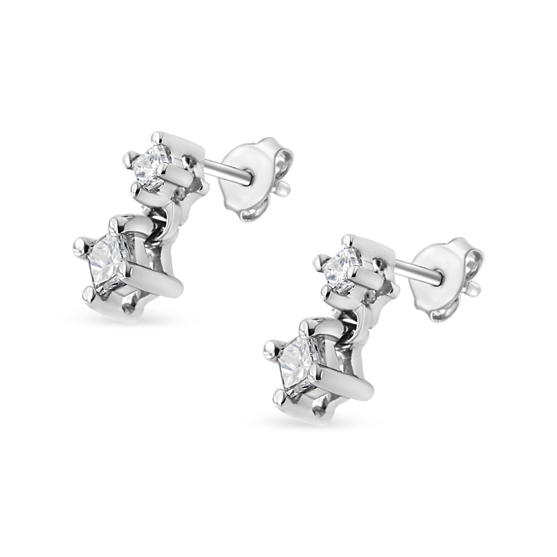 Pair of white metal stud earrings with four white princess-shaped gemstones in prong settings, shown at an angle.