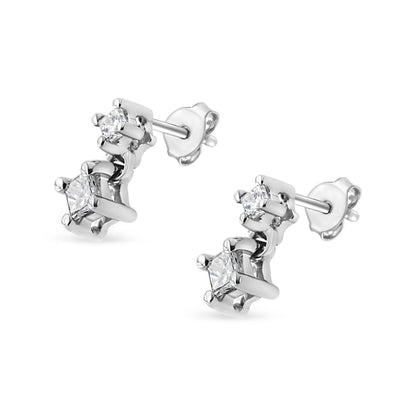 Pair of white metal stud earrings with four white princess-shaped gemstones in prong settings, shown at an angle.