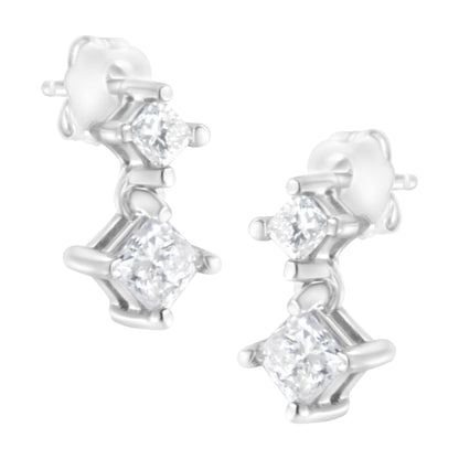 Close-up front angle of white metal earrings with two prong-set princess-shaped white gemstones on each earring.