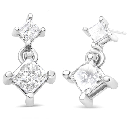 Pair of white metal earrings with two prong-set princess-shaped white gemstones each, shown at a slight angle on a white background.