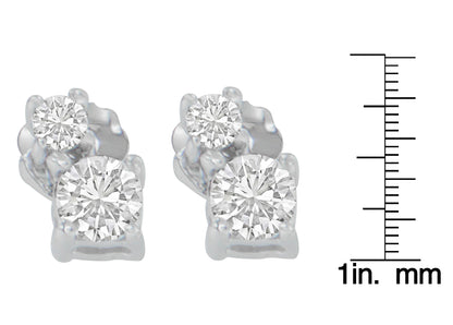 Close-up front view of white metal earrings with two round white gemstones in prong settings, shown next to a ruler for size reference.