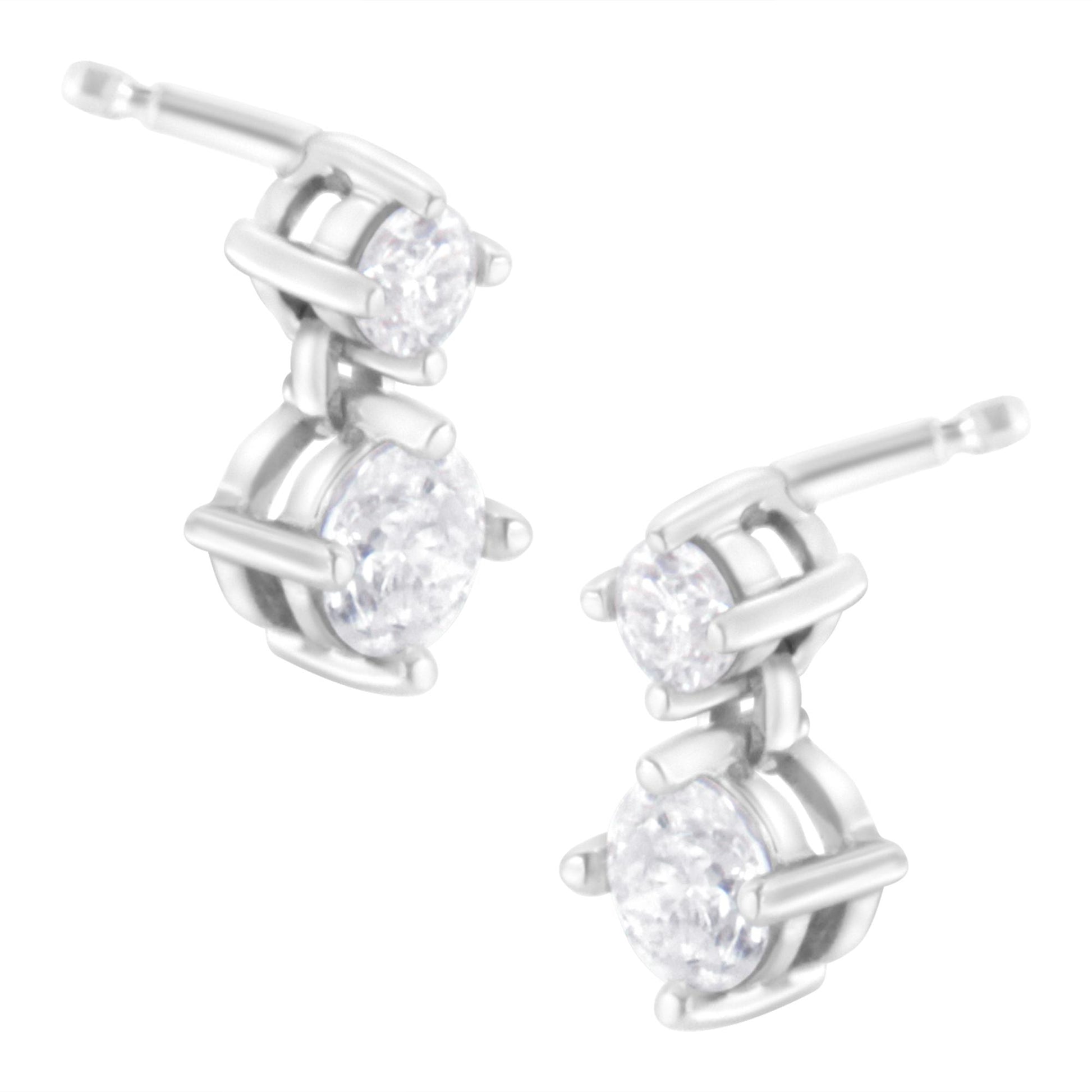 Pair of white metal earrings with two round white gemstones in prong settings, shown from a front angle.