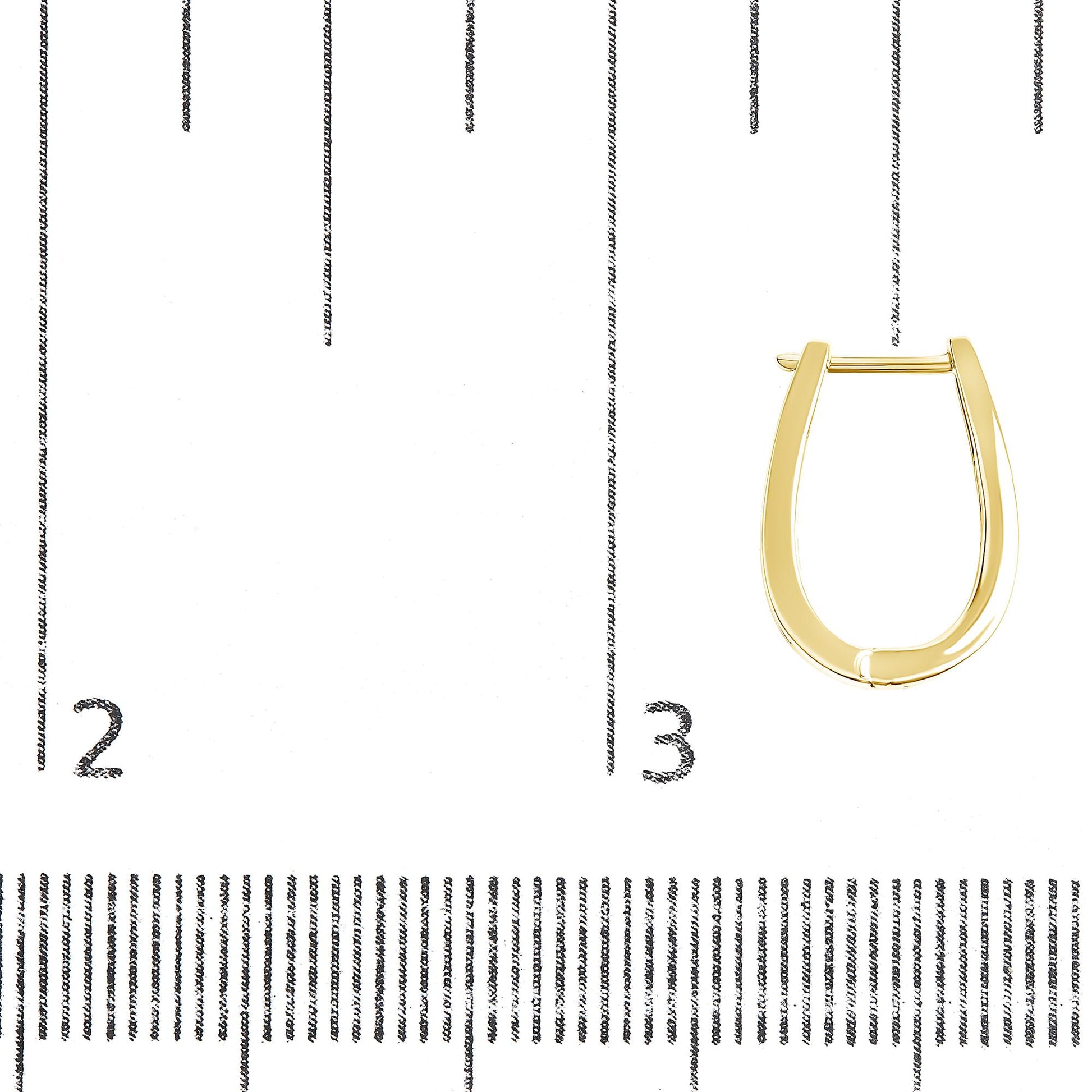 Close-up front view of a single yellow metal hoop earring on a ruler for size reference.