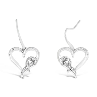 Pair of white metal heart-shaped earrings with pave-set round white gemstones, shown from a front angle.