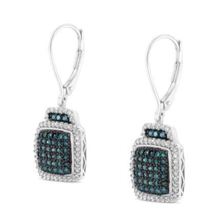 Front angled view of white metal dangle earrings with square-shaped clusters of blue gemstones in pave setting, surrounded by white gemstones in prong setting.