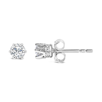 White metal stud earrings with a round white gemstone in a six-prong setting and a band of small round white gemstones in a pave setting, shown from both frontal and side angles.
