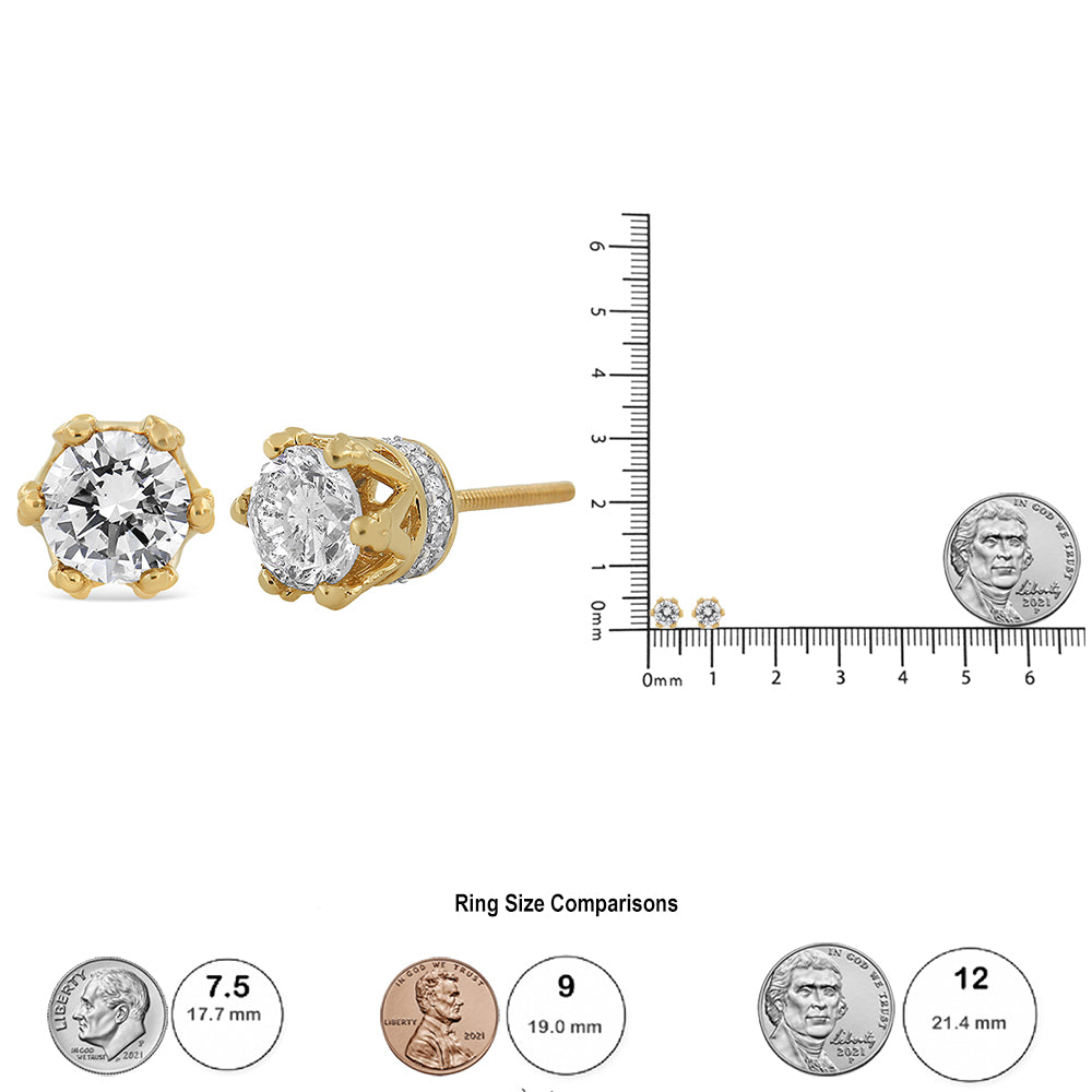 Close-up front and side view of yellow metal stud earrings with a large round white gemstone in prong setting surrounded by smaller round white gemstones in pave setting, displayed next to a ruler and coins for size reference.
