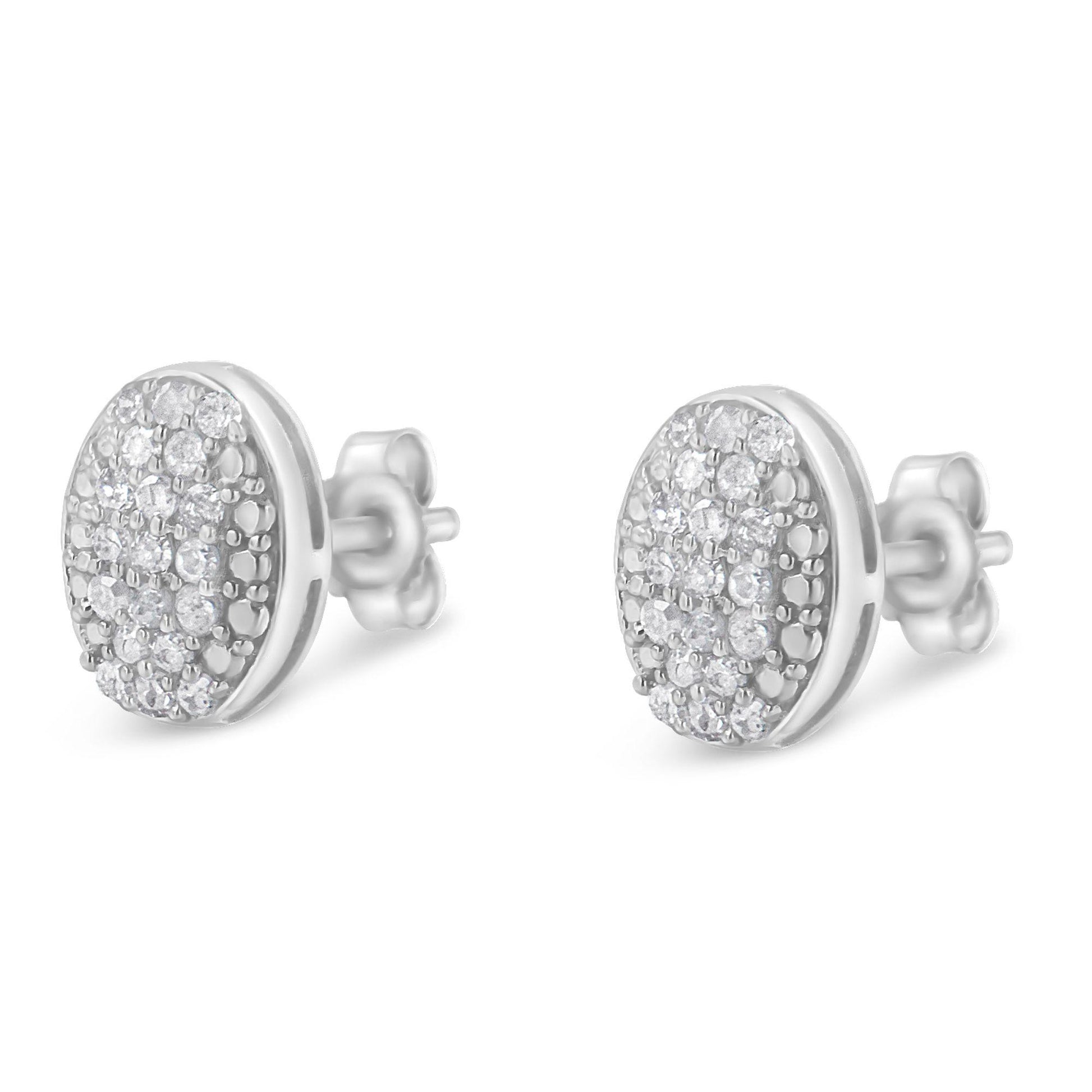 Pair of white metal oval stud earrings with multiple round white gemstones in prong settings, shown from a front-side angle.