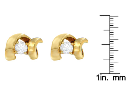 Close-up front view of yellow metal earrings with round white gemstones in prong settings, shown next to a ruler for size reference.