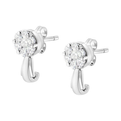 Close-up side angle of a pair of white metal stud earrings with cluster round white gemstones in prong settings and a curved metal detail hanging below.