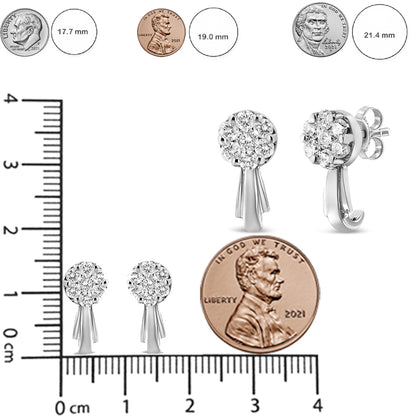 Pair of white metal earrings with round clusters of white gemstones in prong settings, shown from front and side angles, placed on a ruler and next to coins for size reference.
