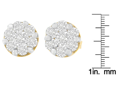 Close-up front view of yellow stud earrings with round white gemstones in prong settings, shown next to a ruler for size reference.