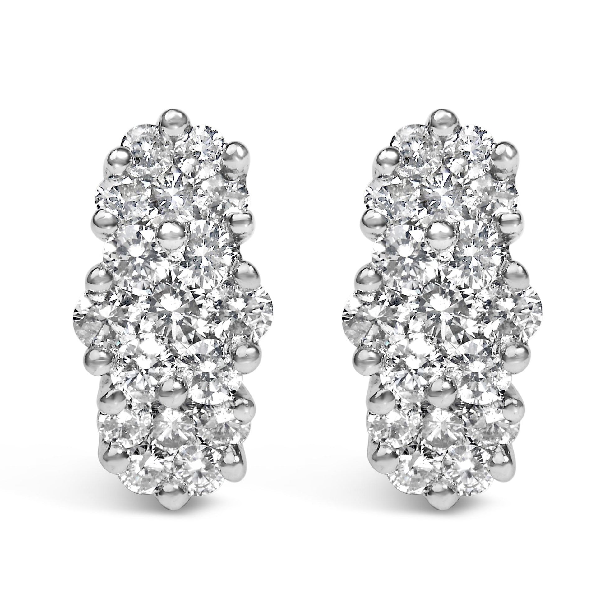 Close-up front view of yellow metal earrings with multiple round white gemstones in prong settings.