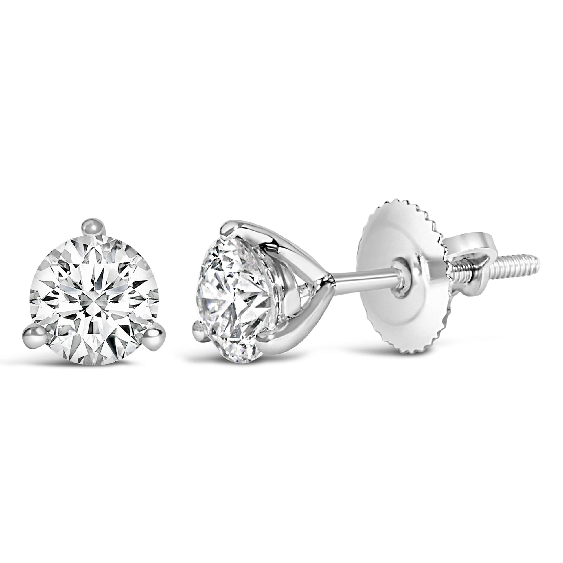 Close-up of a pair of white metal stud earrings with round white gemstones in a 3-prong setting, shown from front and side angles on a white background.