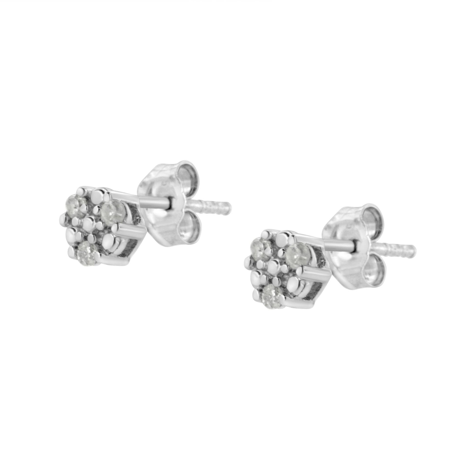 Close-up angled view of white metal stud earrings with cluster of round white gemstones in prong settings.