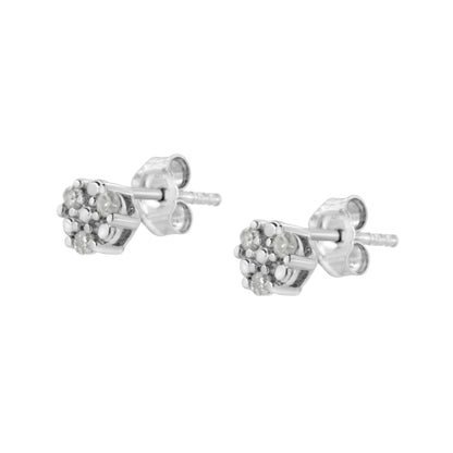 Close-up angled view of white metal stud earrings with cluster of round white gemstones in prong settings.