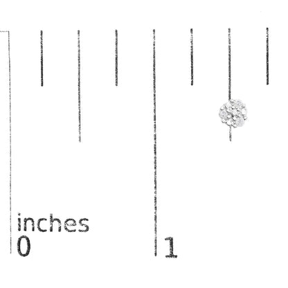 Close-up front view of a white metal cluster earring with round white gemstones in prong settings, placed on a ruler for size reference.
