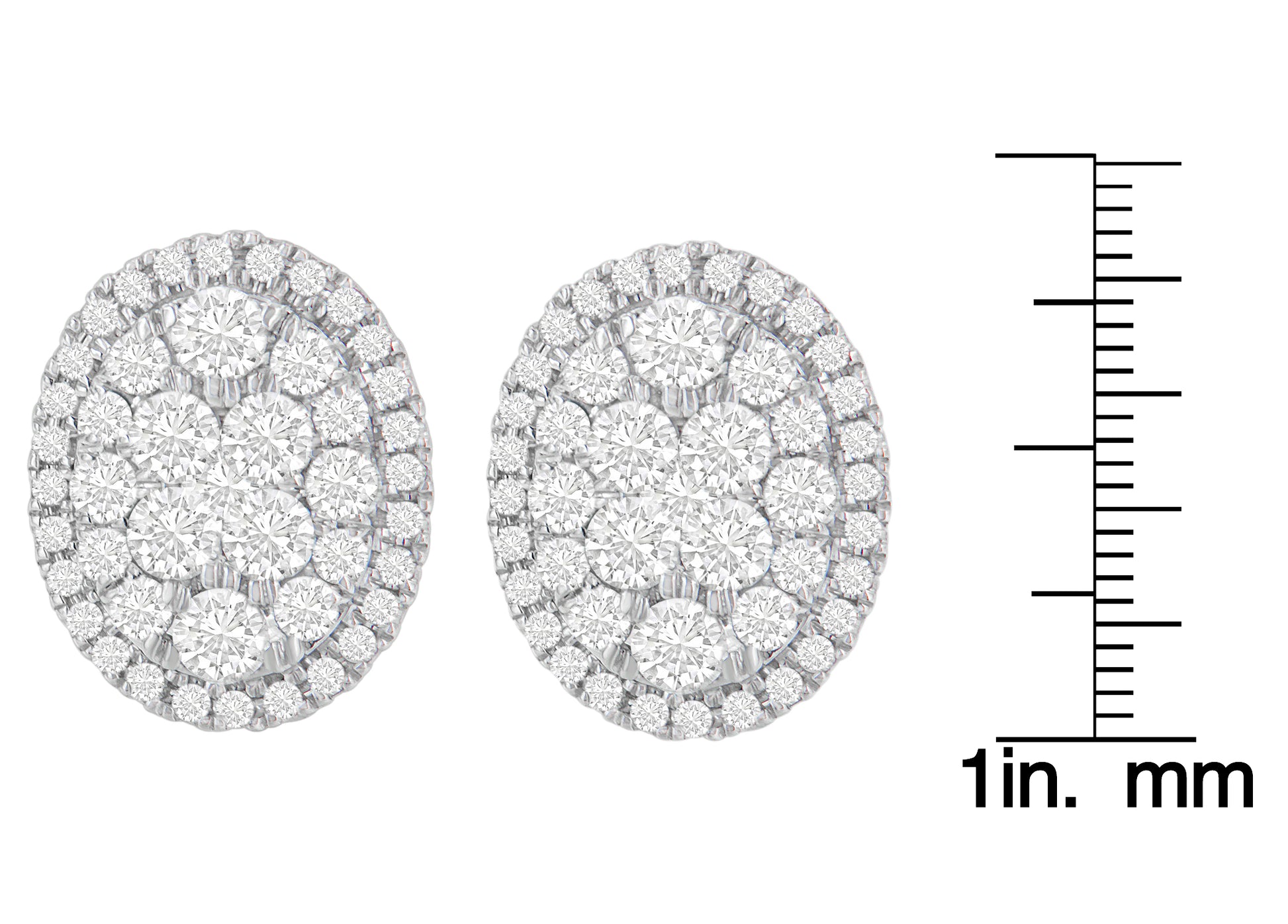 Pair of yellow metal oval earrings set with multiple round white gemstones in prong settings, shown from front on with a ruler for size reference.