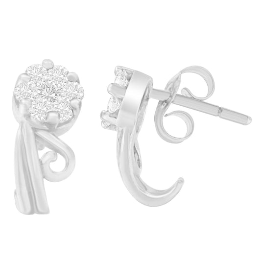 Front and side angled view of white metal earrings with round white gemstones in prong settings and scroll design accents.
