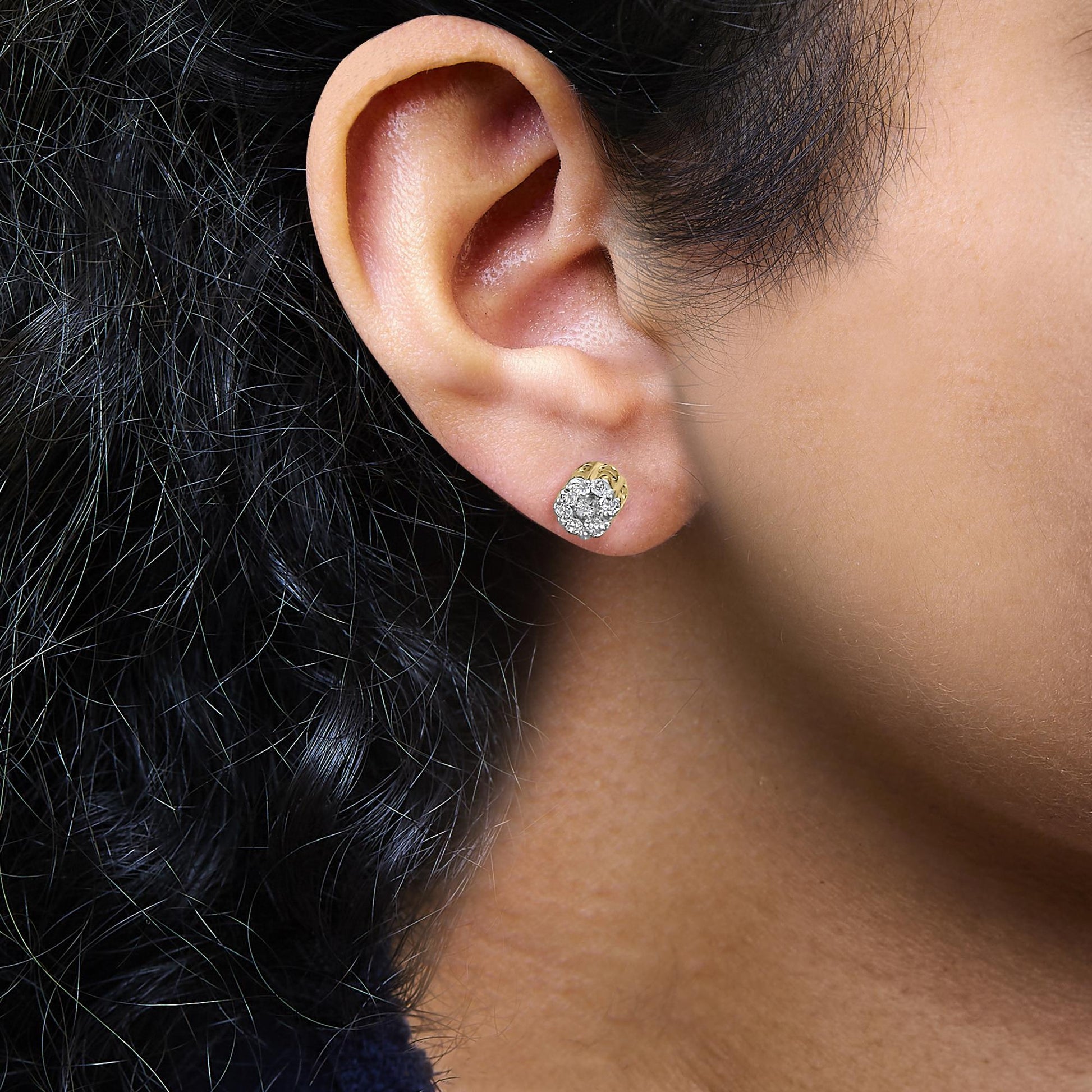 Close-up side view of a yellow metal earring featuring multiple round white gemstones in a cluster setting, worn on a model's ear.