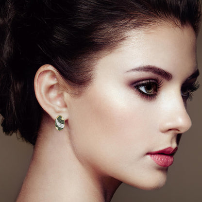 Side view of a model wearing yellow metal earrings with white and blue round pave-set gemstones in an oval design.
