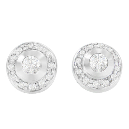 Front view of a pair of white metal round stud earrings, each featuring a central round gemstone in bezel setting surrounded by a circle of smaller round gemstones in prong settings.