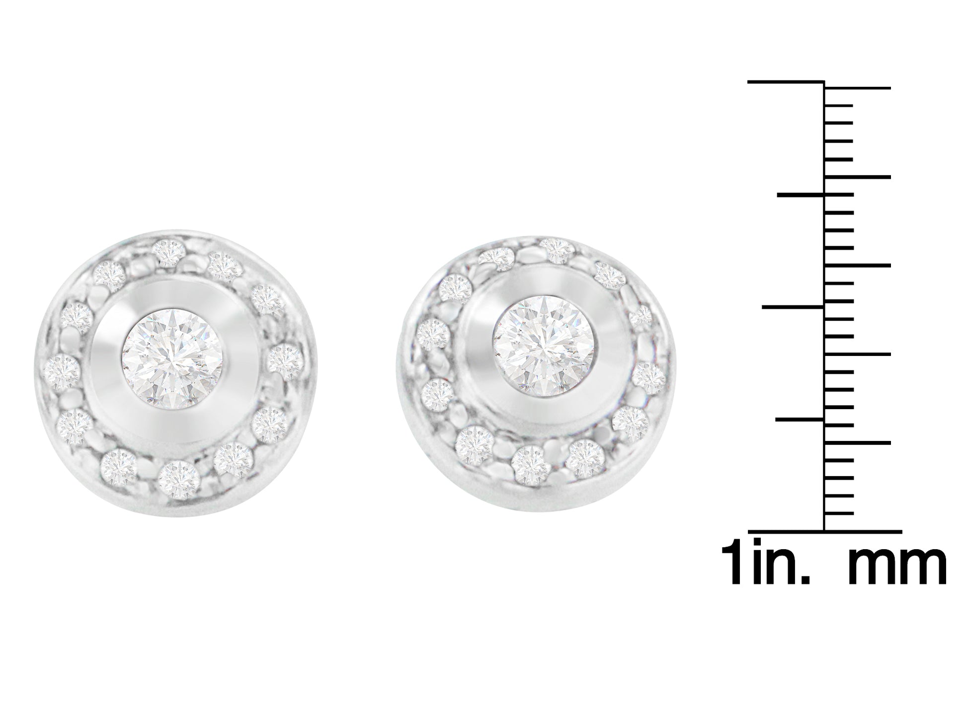 Front-facing view of a pair of white metal round earrings with central white gemstones in bezel settings surrounded by smaller white gemstones in prong settings, shown on a ruler for size reference.