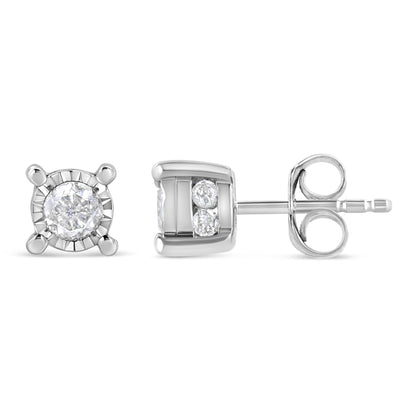 Pair of white metal stud earrings shown from front and side angles, featuring one round white gemstone in a miracle setting and two smaller round white gemstones in a channel setting on each earring.