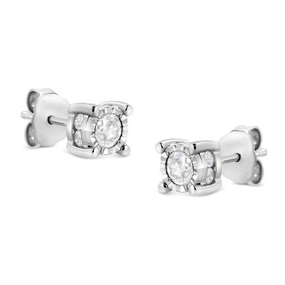Pair of white metal stud earrings with round white gemstones in miracle and channel settings, shown at a slight angle.