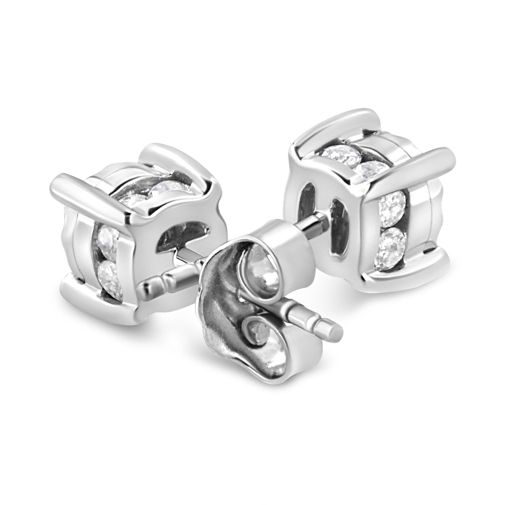 Close-up front angle of a pair of white metal stud earrings with round white gemstones in miracle and channel settings.