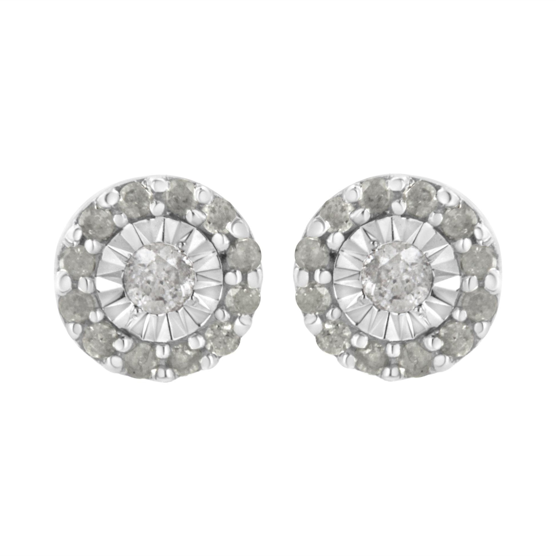 Front view of a pair of white metal round stud earrings featuring a central white gemstone in miracle setting, surrounded by a circle of smaller white gemstones in shared prong setting.