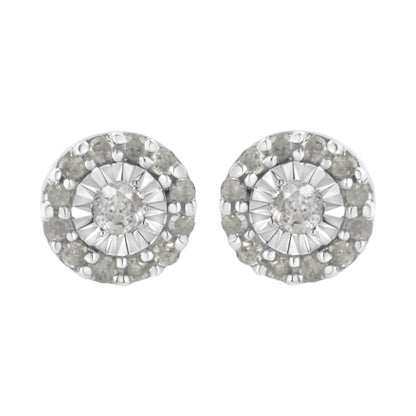 Front view of a pair of white metal round stud earrings featuring a central white gemstone in miracle setting, surrounded by a circle of smaller white gemstones in shared prong setting.