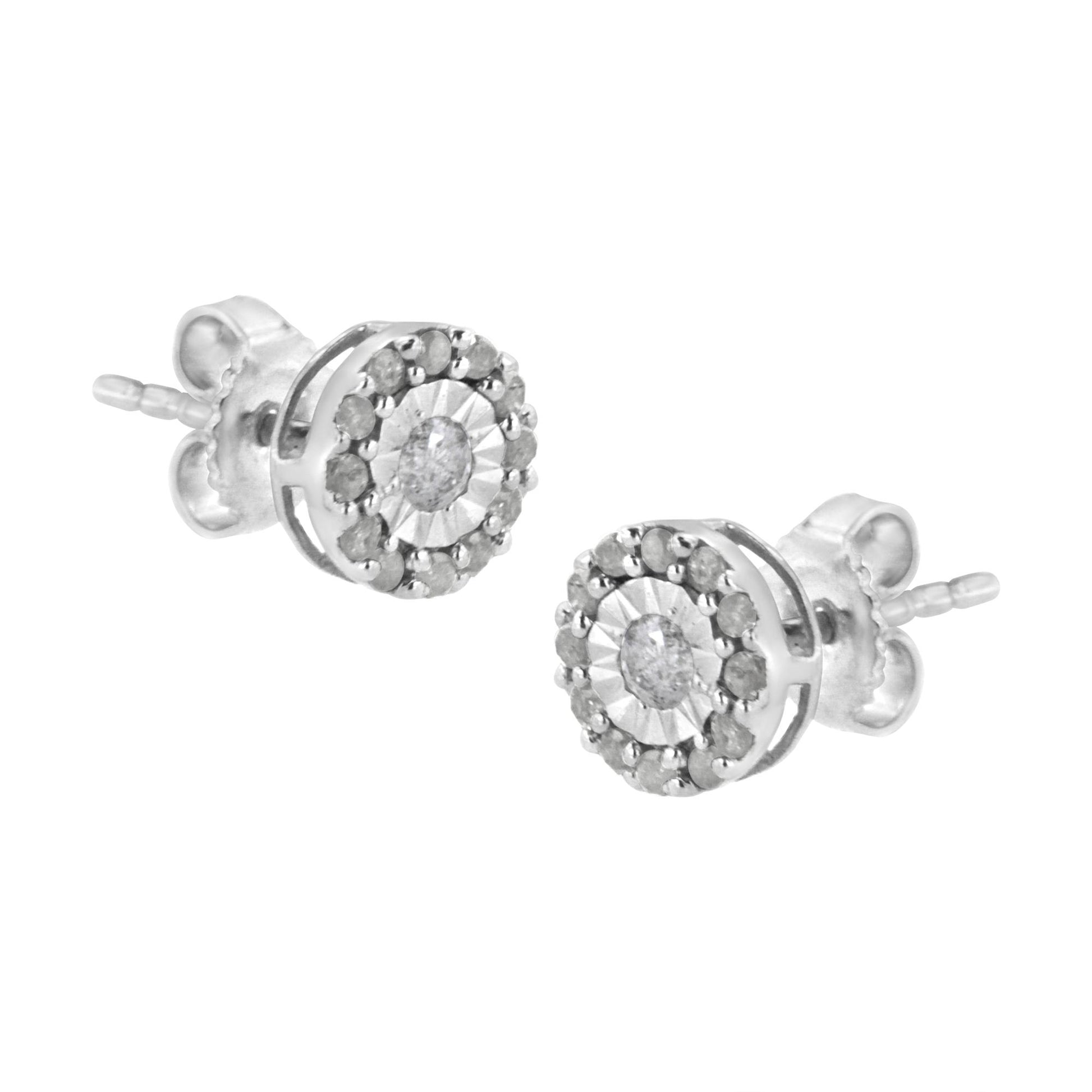Pair of white metal stud earrings with round white gemstones in a central setting, surrounded by smaller round white gemstones, shown from a slightly angled side view.