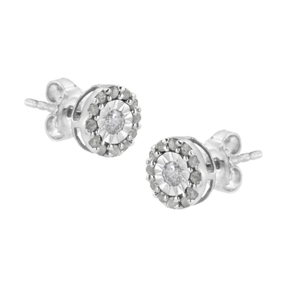 Pair of white metal stud earrings with round white gemstones in a central setting, surrounded by smaller round white gemstones, shown from a slightly angled side view.