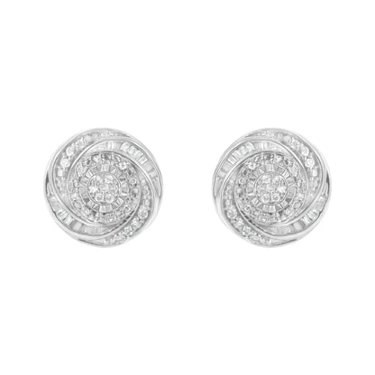 Front view of a pair of white metal round earrings with swirling patterns set with white round and baguette gemstones.