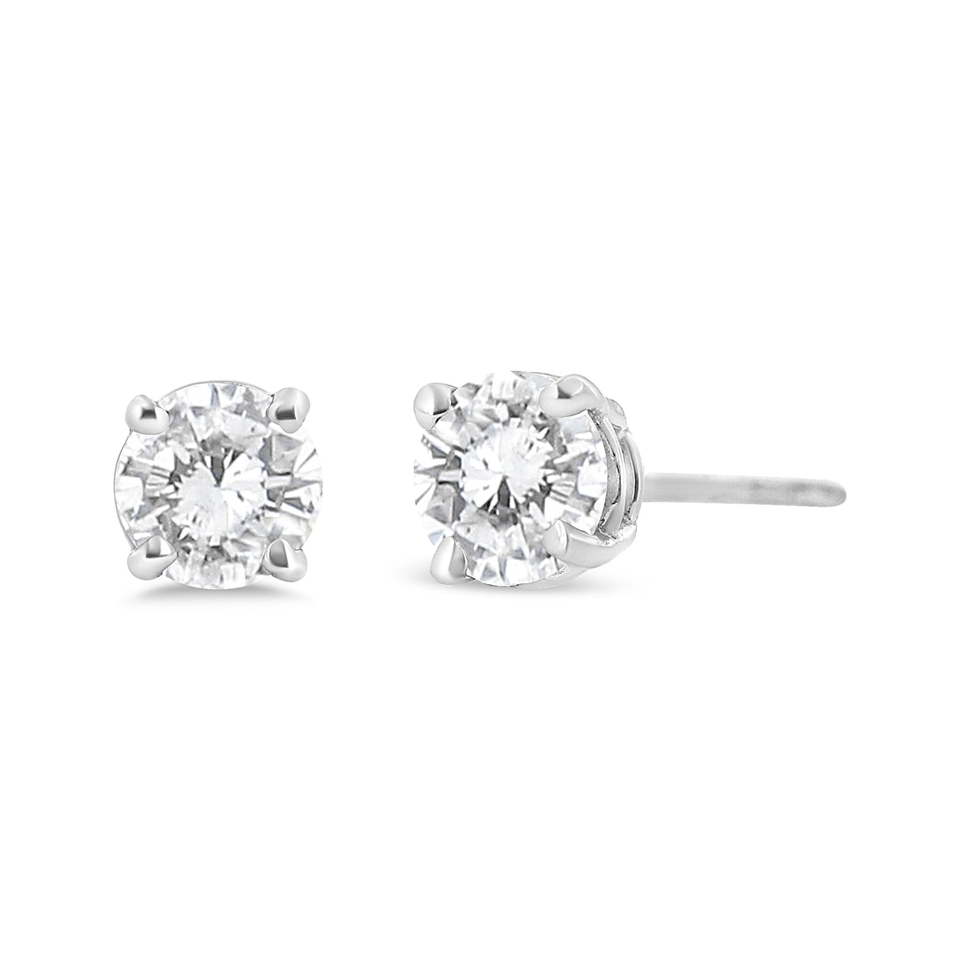 Close-up front and side angle of white metal stud earrings with round white gemstones set in four-prong settings.