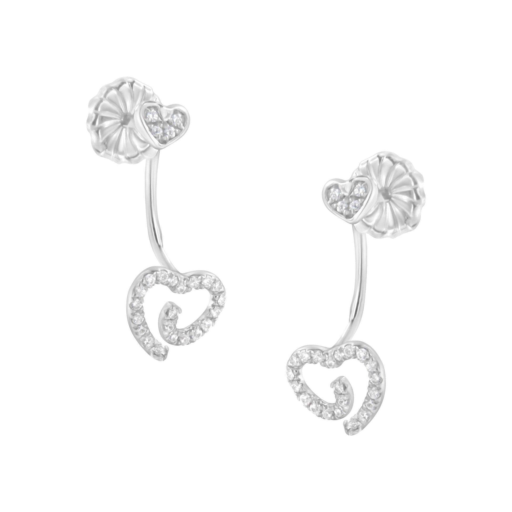 White metal earrings with heart-shaped designs adorned with white gemstones in pave setting, shown from a slightly angled front view.