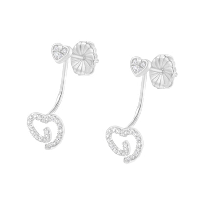 Pair of white metal earrings with heart-shaped studs featuring small white gemstones and connected to larger open-heart shapes adorned with white gemstones, shown from a front angle.