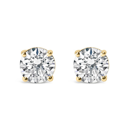 Front view of yellow metal stud earrings each featuring a round white gemstone in a four-prong setting.