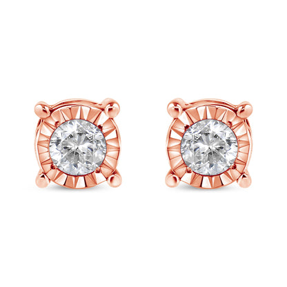Front view of a pair of rose metal stud earrings each featuring a round white gemstone with a miracle setting.