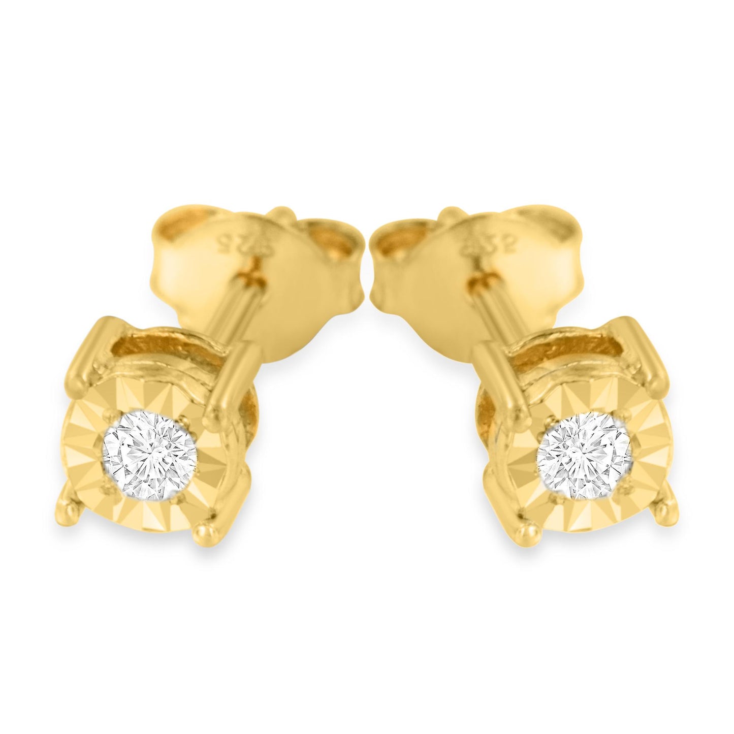 Close-up front angle of a pair of yellow metal stud earrings each featuring a single round white gemstone in a miracle setting.