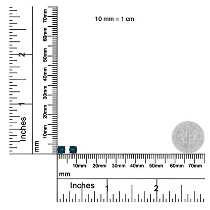 Close-up shot of two small white round-shaped earrings with blue gemstones, displayed on a ruler for size reference.